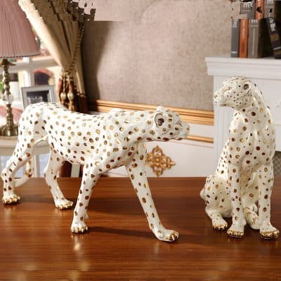 Ceramic leopard figurines with gold polka dots, decorative home accents in elegant interior setting.