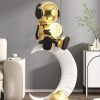 Moon lamp with astronaut figure sitting on a modern crescent moon shelf in stylish living room decor, perfect for adding a cozy glow to your bedroom or nursery.