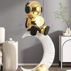 Moon lamp with astronaut figure sitting on a modern crescent moon shelf in stylish living room decor, perfect for adding a cozy glow to your bedroom or nursery.