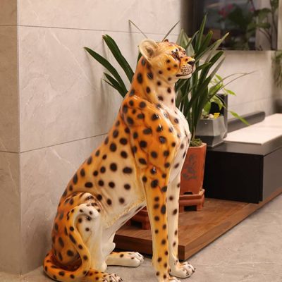 Vibrant cheetah sculpture next to houseplants inside Monalisa Medical Store, showcasing unique decor elements and attention to detail in interior design for a welcoming medical environment.