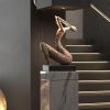 Elegant bronze sculpture of a bird figure displayed on a marble pedestal at Monalisa Store, showcasing luxury home decor and art pieces.