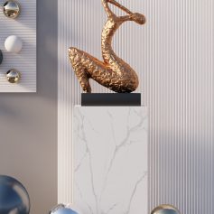 Elegant golden sculpture displayed on a white marble pedestal, modern interior decor, perfect for luxury art collections or interior design accents.