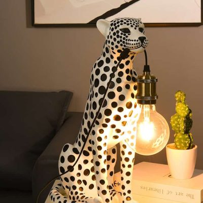Polka dot leopard table lamp with warm glowing light, modern home decor for living room or bedroom. Unique animal-shaped lighting fixture showcasing contemporary interior design.