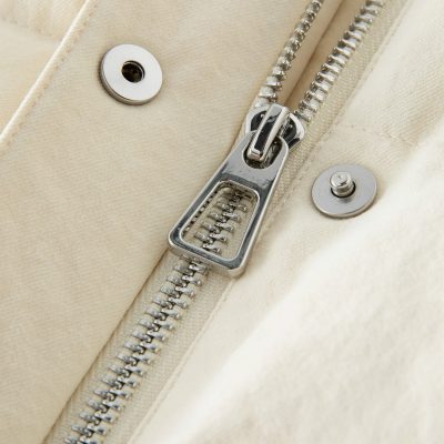 High-quality beige jacket zipper, close-up of silver metal zipper and snap buttons, luxury fashion detail for stylish wear, Monalisa Medical store.