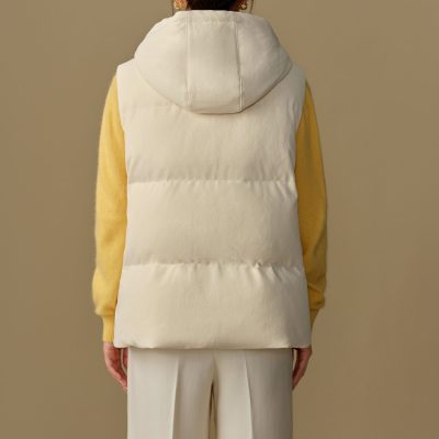 Comfortable white puffer vest with hood, layered over a yellow sweater, showcasing trendy, stylish outerwear for cold weather, perfect for casual and outdoor activities, emphasizing comfort and warmth.