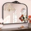 Luxurious decorative mirror with ornate black frame, elegant chandelier reflection, and stylish floral arrangement, perfect for enhancing interior decor in homes and living spaces.