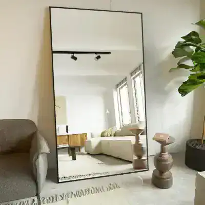 Large full-length mirror in modern living room with natural light, cozy seating, and contemporary decor, suitable for home or boutique retail spaces.