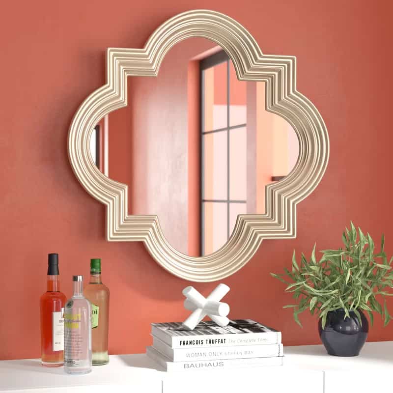 Luxury monalisa store mirror with decorative frame behind a white table with bottles and a plant for interior decor opt.