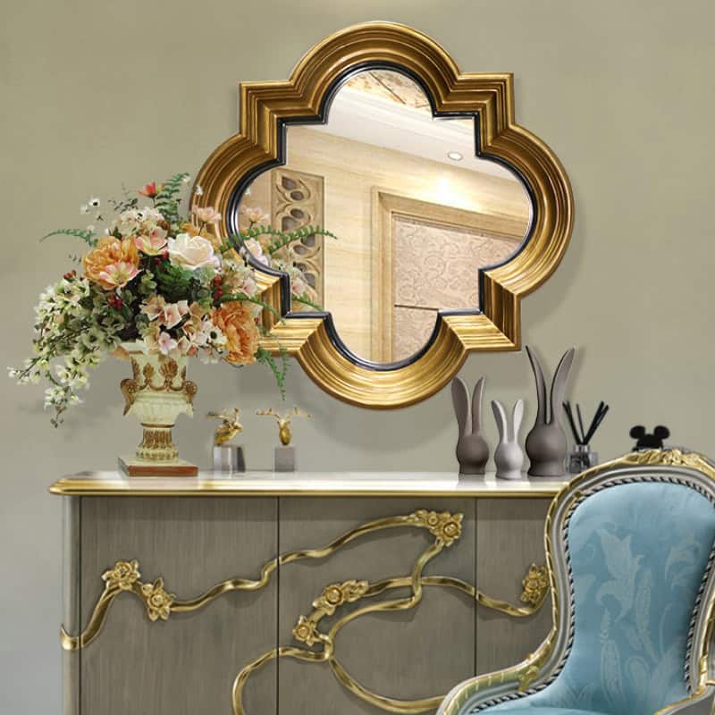 Luxurious gold-framed mirror with floral decor and stylish vases on a sophisticated console table at Monalisa Store. Elegant interior design for premium beauty and aesthetic services.