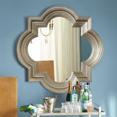 Luxury modern mirror with ornate silver frame reflecting elegant interior design for Monalisa Medical store showcase.