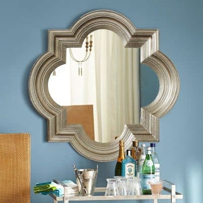 Luxury modern mirror with ornate silver frame reflecting elegant interior design for Monalisa Medical store showcase.