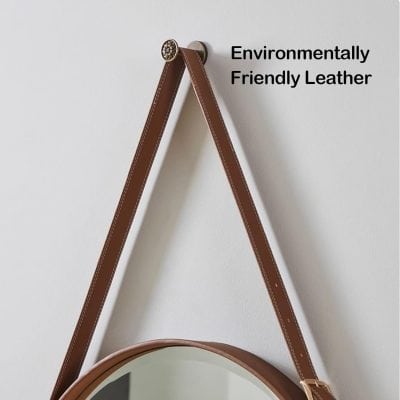 Soft focus on brown leather strap with white stitching, hanging on a white wall, emphasizing environmentally friendly leather material.