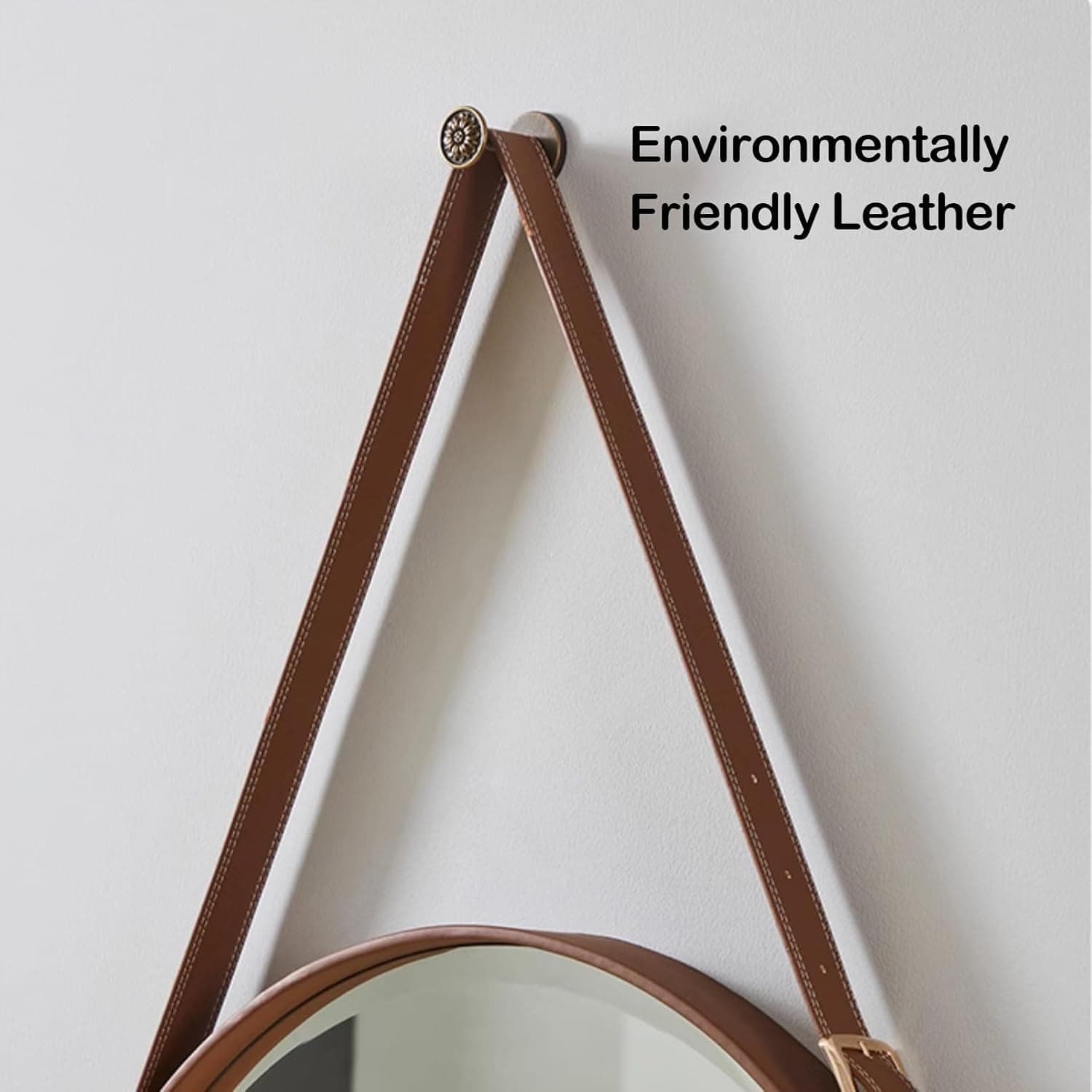 Soft focus on brown leather strap with white stitching, hanging on a white wall, emphasizing environmentally friendly leather material.