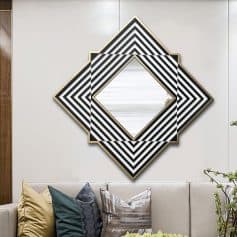 Contemporary geometric wall mirror with black, white, and gold accents in a modern living room. Stylish decor and sophisticated design enhance the space's aesthetic appeal.