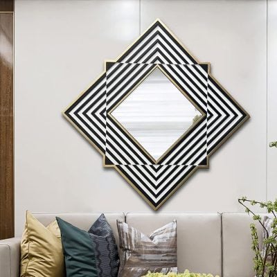Contemporary geometric wall mirror with black, white, and gold accents in a modern living room. Stylish decor and sophisticated design enhance the space's aesthetic appeal.