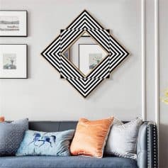 Vibrant geometric black and white wall art above a stylish sofa with colorful pillows in a modern living room.