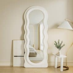 Wavy-edge white framed full-length mirror in a stylish, modern bedroom with neutral tones and minimalist decor, ideal for home or professional optometry clinic settings.