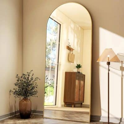 Reflective full-length mirror in a cozy, modern entryway with natural light, wooden cabinet, potted plant, and stylish decor, perfect for home or office interiors.