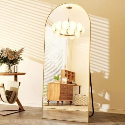 Elegant full-length gold-framed standing mirror in a modern interior space, reflecting stylish wooden furniture and soft lighting. Perfect for home decor, bedroom, or living room enhancements.