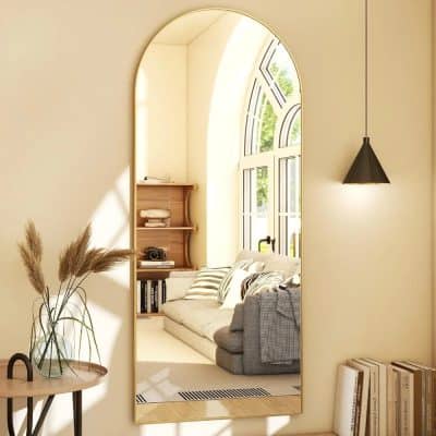 Minimalist full-length mirror with sleek gold frame reflecting a cozy living room with natural lighting, stylish cushions, and modern decor, perfect for contemporary home aesthetics.