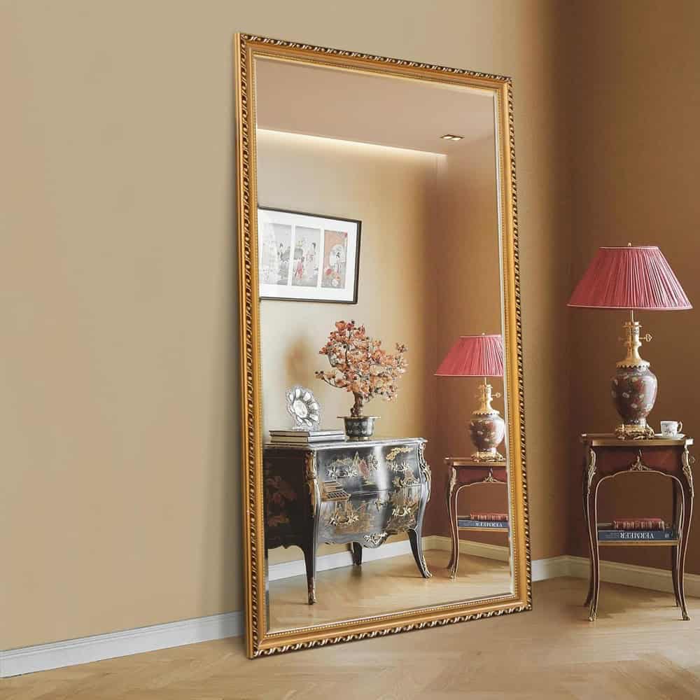 Elegant full-length mirror with gold decorative frame reflecting antique-style furniture and floral lamps, ideal for enhancing luxury and classic aesthetic in interior decor.