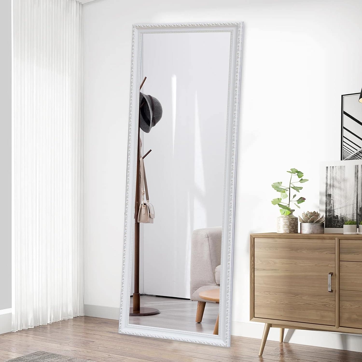 Elegant full-length white framed mirror in modern bedroom interior with hats and handbag on stand, natural light, minimalist decor, showcasing stylish and functional home essentials.