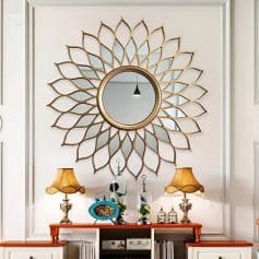 Decorative round mirror with gold petal frame in elegant interior decor for home aesthetic enhancement.