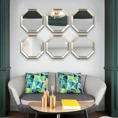 Reflections of chandelier in gold octagon mirrors, modern living room interior, stylish wall decor, cozy seating with colorful pillows, contemporary home design, Monalisa Medical store inspiration.