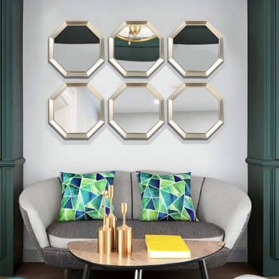 Reflections of chandelier in gold octagon mirrors, modern living room interior, stylish wall decor, cozy seating with colorful pillows, contemporary home design, Monalisa Medical store inspiration.