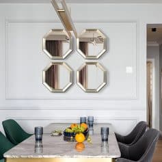 Elegant dining room with modern decor, featuring four stylish wall mirrors and a marble table set with glasses and fresh fruit, perfect for a contemporary home or upscale space.