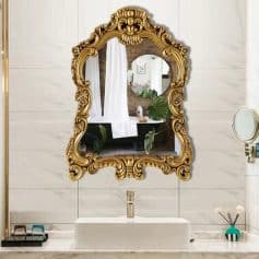 Luxurious gold ornate mirror above a modern white sink in Monalisa Medical store showcasing elegant bathroom decor and high-end interior design.
