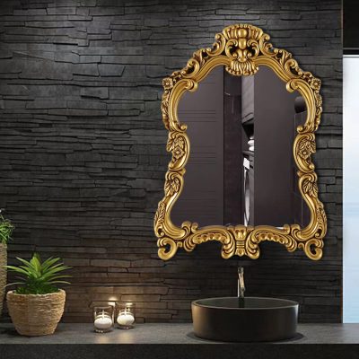 Ornate gold-framed wall mirror above black vessel sink in modern Monalisa medical store interior, with dark textured wall background and decorative candles, creating a luxurious and elegant ambiance for a healthcare retail space.