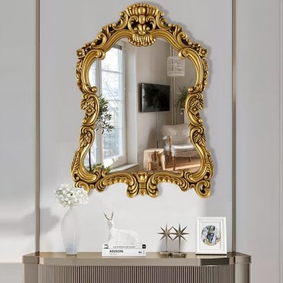 Ornate gold-framed decorative mirror in elegant living room setting, perfect for enhancing interior decor and adding a touch of luxury.