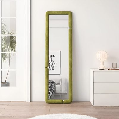 Floor-length green upholstered mirror leaning against white wall in modern bedroom setting, minimalist decor, natural light, stylish interior design, contemporary home decor, Monalisa Store opt.