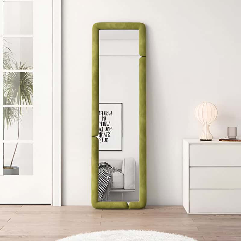 Floor-length green upholstered mirror leaning against white wall in modern bedroom setting, minimalist decor, natural light, stylish interior design, contemporary home decor, Monalisa Store opt.