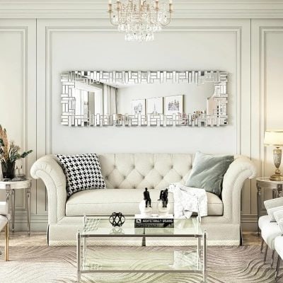 Elegant modern living room with luxurious white sofa, decorative pillows, stylish glass coffee table, and a large geometric mirror, showcasing sophisticated interior design for Monalisa Medical Store.