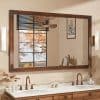 Elegant bathroom mirror with wooden frame and modern lighting, reflecting autumn trees outside window, perfect for enhancing home decor and interior design.