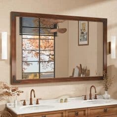 Elegant bathroom mirror with wooden frame and modern lighting, reflecting autumn trees outside window, perfect for enhancing home decor and interior design.