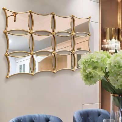 Luxurious gold-framed geometric mirror on neutral wall at Monalisa Medical Store, creating an elegant aesthetic for skincare and beauty ambiance.
