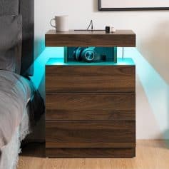 Modern wooden nightstand with built-in LED lighting, storing headphones and sitting next to a cozy bed in a stylish bedroom setup.