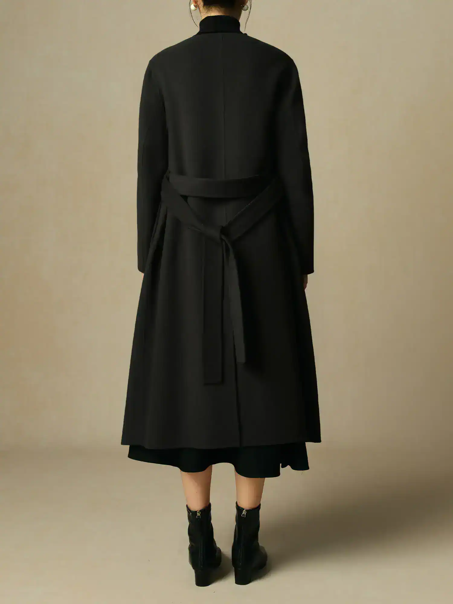 Modern black trench coat with a waist belt, stylish and elegant outerwear perfect for fall and winter fashion.