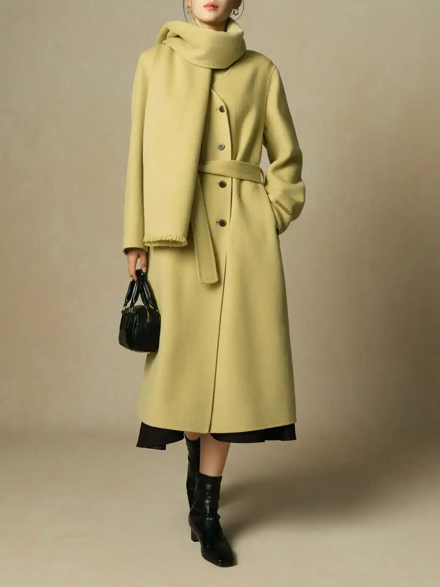 Luxurious yellow women's coat with matching scarf, stylish black ankle boots, and a small black handbag, perfect for fall or winter fashion.