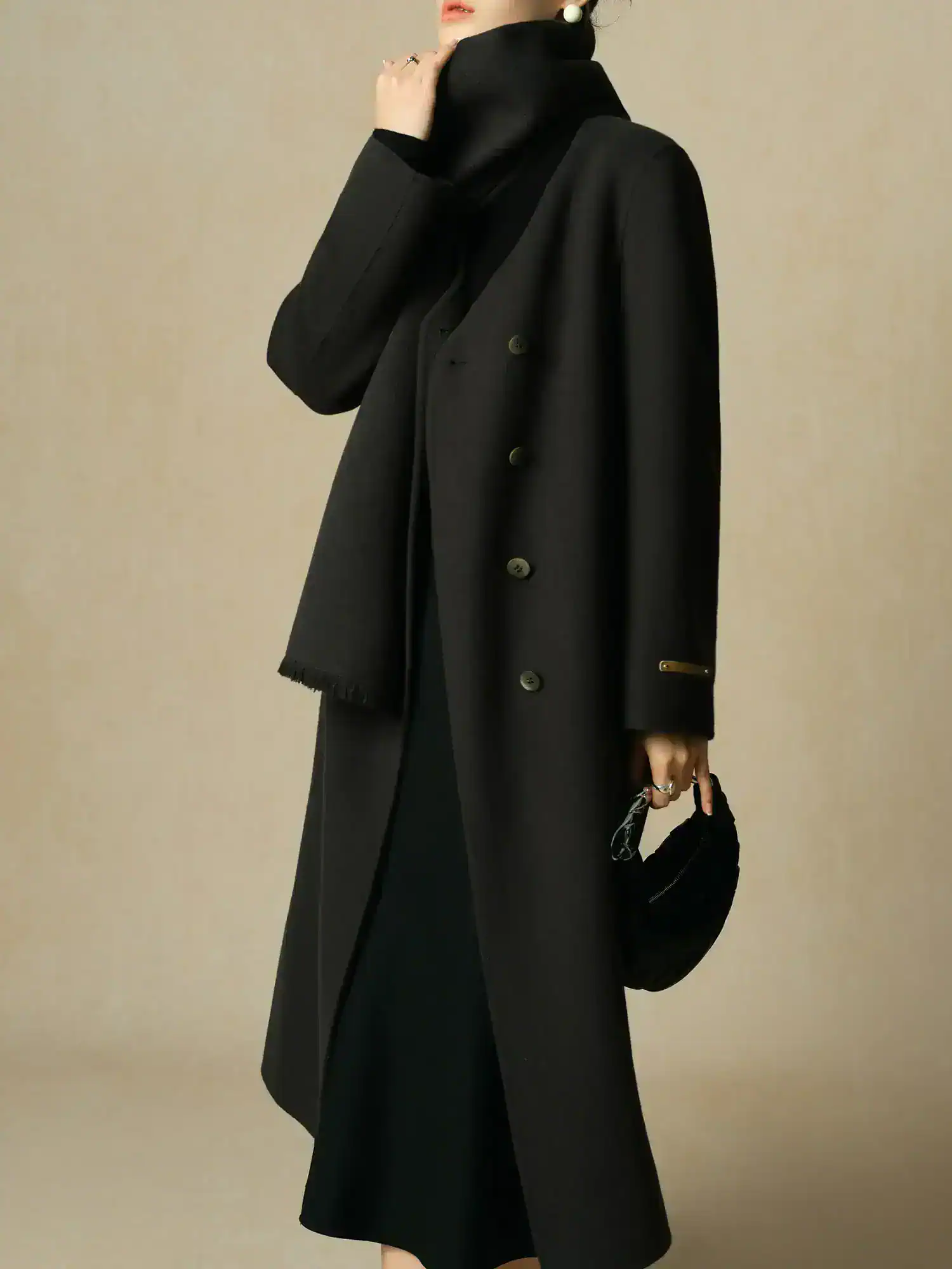 Elegant black long coat with stylish details, perfect for winter fashion and professional wear. Sophisticated outerwear suitable for cold weather and fashionable outings.