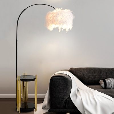 Soft illuminated feather lamp on modern living room side table with cozy gray sofa, ideal for stylish interior lighting and home decor.