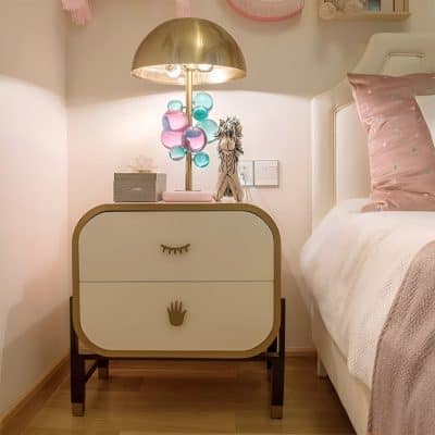 Colorful modern nightstand with eye and hand designs in a cozy bedroom setting for a stylish home decor look.