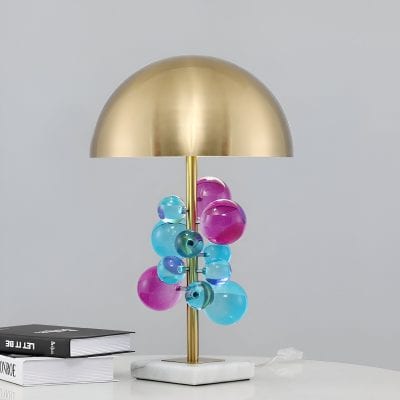 Colorful glass ball table lamp with gold finish, modern design, decorative lighting for home or office.