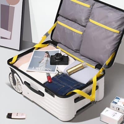 Suitcase with travel essentials, including clothes, camera, and skincare products, perfect for a stylish and organized trip. Ideal for travelers seeking convenience and fashion in their travel accessories.