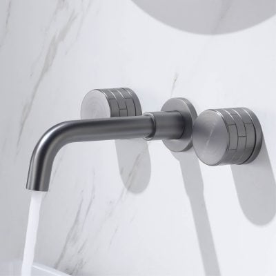 Modern stainless steel bathroom faucet for medical or dental clinics, displaying water flowing on a white marble wall background.