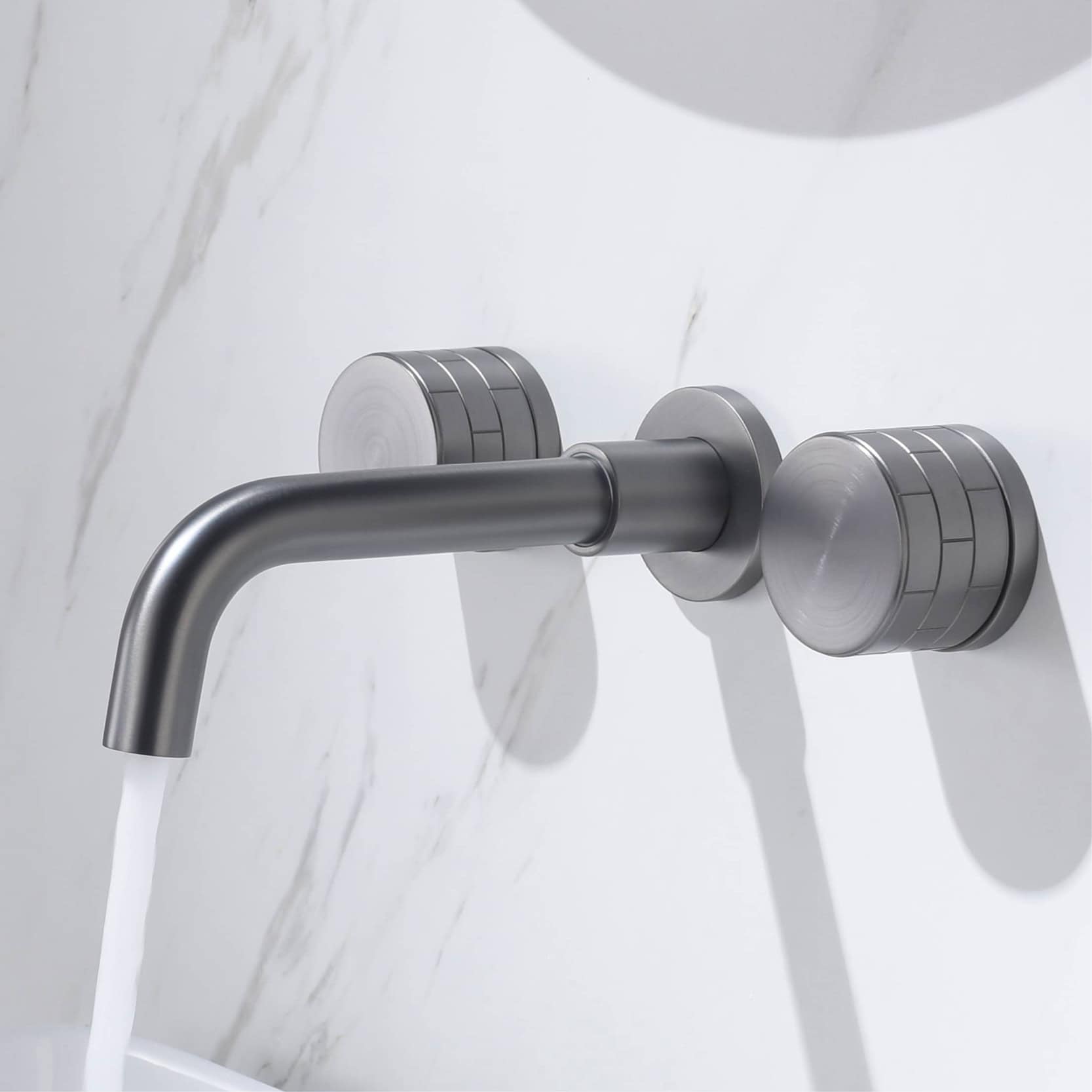 Modern stainless steel bathroom faucet for medical or dental clinics, displaying water flowing on a white marble wall background.