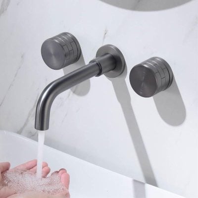 Polished stainless steel faucet with water running into hand, modern bathroom fixture.